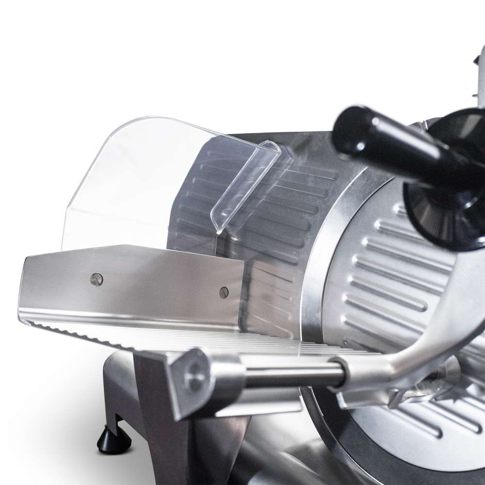 Close-up view of the industrial meat slicer's sliding carriage, the blade and the food holder arm in the up position.