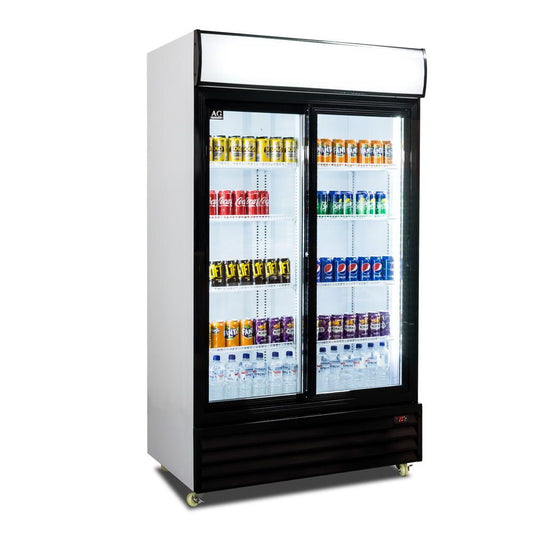 Angled view of sliding glass doors displays fridge. Populated with beverages, the top light box and main cabin LEDs are on.