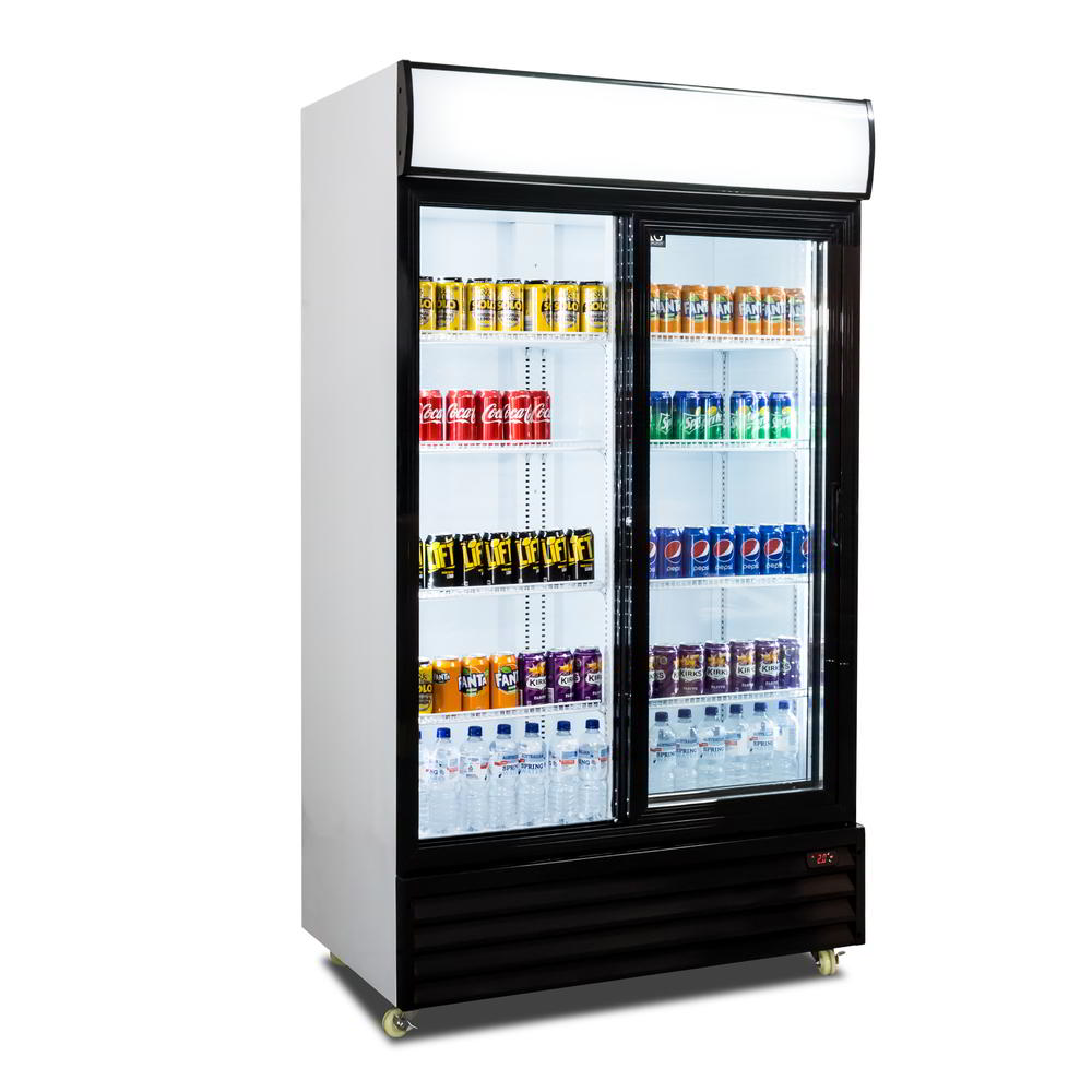 Angled view of a beverage fridge with the left sliding door opened. Populated with beverages and all lights are turned on.